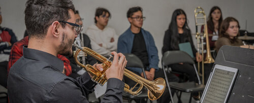 Una trompeta proyecta su voz ante una audiencia atenta que también aprende escuchando. Foto: María Fernanda Londoño, Unimedios.